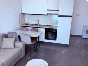 a living room with a couch and a table and a kitchen at Rana Hedhun Seaside 1 in Lezhë