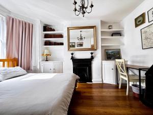 a bedroom with a bed and a desk and a fireplace at The OX1 in Oxford
