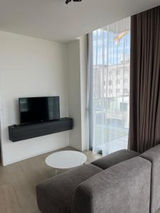 a living room with a couch and a tv at El Mirador - Quality Stay in Ostend