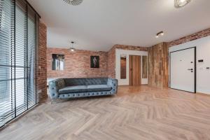 un salon avec un canapé et un mur de briques dans l'établissement Apartament Loft & glow Montownia, à Gdańsk 2 autres photos