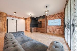 un salon avec un canapé et un mur de briques dans l'établissement Apartament Loft & glow Montownia, à Gdańsk