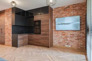 une cuisine avec un mur de briques et une télévision dans l'établissement Apartament Loft & glow Montownia, à Gdańsk