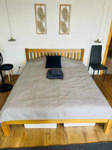 a large bed in a room with two chairs at Linden apartment in Preiļi