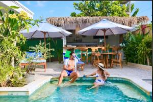 a man and a woman sitting in a swimming pool at Villa AmoreMia in Gili Trawangan