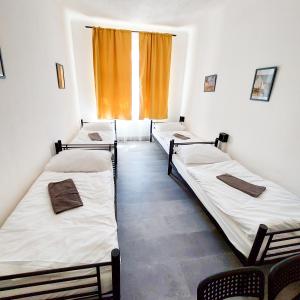 three beds in a room with a window at Traveller's room F1 u výstaviště in Prague +14 photos