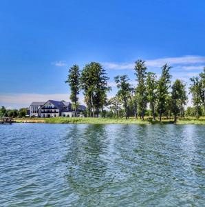 a house on the shore of a lake at Natural Hotel-Ostróda-basen na III kondygnacji-pokoje wellness z saunami in Ostróda