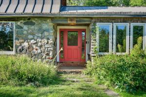 una puerta de entrada roja de una casa de piedra en 4 Br Sleeps 8 - Kayaks - Fire Pit - Dog Friendly, en Danville