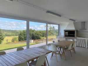 a kitchen and dining room with a wooden table and chairs at Casa da Marola in Zas