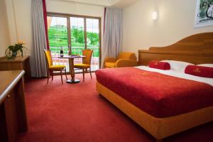 ein Hotelzimmer mit einem Bett und einem Tisch und Stühlen in der Unterkunft Hotel Venko in Dobrovo