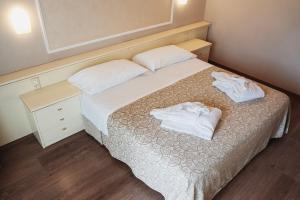 una camera da letto con un letto con due asciugamani bianchi di Hotel Terme Marconi a Montegrotto Terme