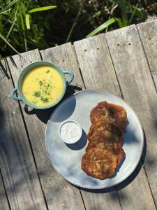 a plate of food with a pot of soup and a piece of meat at Stanica Wodna Płaska in Płaska