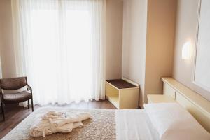 una camera da letto con un letto e un asciugamano sopra di Hotel Terme Marconi a Montegrotto Terme