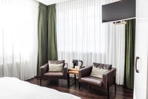 a hotel room with two chairs and a table and a bed at Pension Montmaertre in Zierikzee