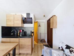 シャテルにあるToison Blanche TBA3 COSY & Mountain 4 Persのキッチン(黒いカウンタートップ、テーブル付)