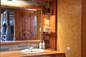 un baño con lavabo y espejo en Kiboko River Camp, en Koito 43 fotos más