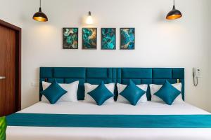 a bedroom with a blue and white bed with blue pillows at Golden Temple Paradise Stays in Amritsar +6 photos