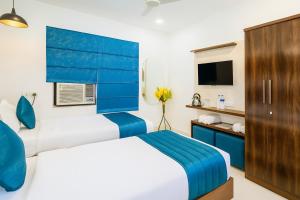 a hotel room with two beds and a tv at Golden Temple Paradise Stays in Amritsar