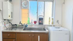a kitchen with a sink and a window at 瀬戸内多賀町302 in Kusukamimachi