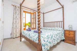 a bedroom with a four poster bed and a window at Ca Na Martina in Cala d´Or +29 photos
