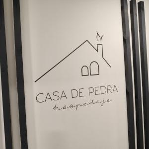 a drawing of a house on a white wall at Casa de Pedra in Melide