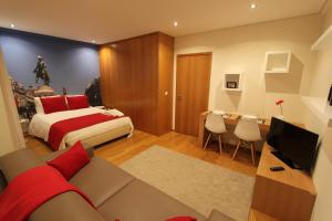 a bedroom with a bed and a desk with a television at BRA.com Apartments Oporto Bonfim in Porto