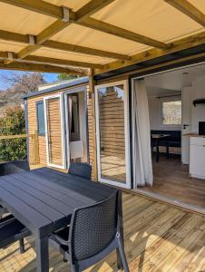 a patio with a table and chairs on a deck at Mobil home climatisé avec piscine in Viviers