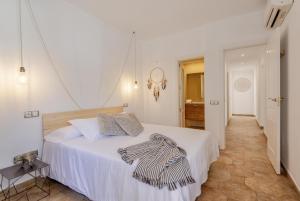 a bedroom with a white bed and a hallway at Villa Calma in Can Picafort