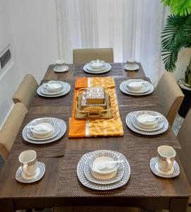 a wooden table with plates and dishes on it at Chic, comfortable house for Rent with Honore Rwanda in Kigali