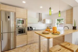 a kitchen with stainless steel appliances and a wooden table at Villa Calma in Can Picafort