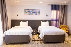 a hotel room with two beds and a chair at Chic, comfortable house for Rent with Honore Rwanda in Kigali