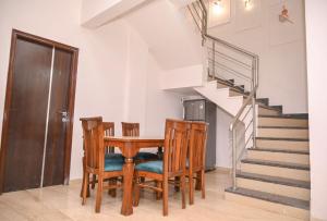 una sala da pranzo con tavolo, sedie e scale di Twilight Stays ll R Villa 3BHK ll Swimming Pool ll AC ll BBQ a Lonavala