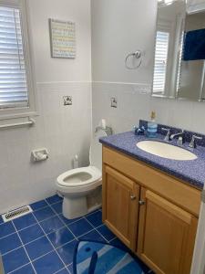 un baño con inodoro y lavabo en Welcome To Your Dream Vacation Rental In The Heart Of Peahala Park, Just Steps Away From The Pristine Beaches Of The Ocean Block, en Peahala Park