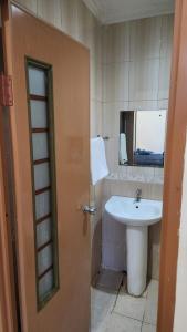 a bathroom with a sink and a mirror at House of Felix - Surabaya Guest House in Surabaya