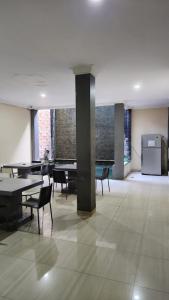 a large room with tables and chairs and windows at House of Felix - Surabaya Guest House in Surabaya