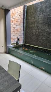 a bathroom with a bathtub with a water fountain at House of Felix - Surabaya Guest House in Surabaya
