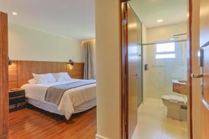 a bedroom with a bed and a glass shower at Ti Voglio Bene in Campos do Jordão +87 photos