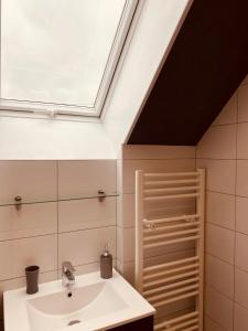 a bathroom with a sink and a skylight at La Maison de Pêcheur in Étaples