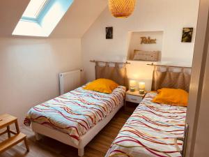 two twin beds in a room with a window at La Maison de Pêcheur in Étaples