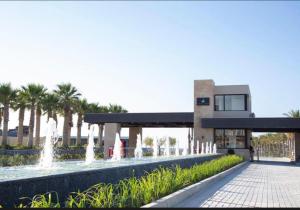 ein Gebäude mit einem Brunnen davor in der Unterkunft Swanlake Lagoon Luxury Villa in Zāwiyat al ‘Awwāmah