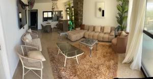 ein Wohnzimmer mit einer Couch sowie Tischen und Stühlen in der Unterkunft Swanlake Lagoon Luxury Villa in Zāwiyat al ‘Awwāmah