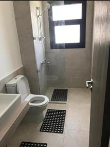 ein Badezimmer mit Dusche, Toilette und Waschbecken in der Unterkunft Swanlake Lagoon Luxury Villa in Zāwiyat al ‘Awwāmah