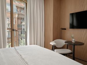 a hotel room with a bed and a window at Bob W Munich Old Town in Munich