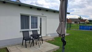 a patio with two chairs and a table and an umbrella at Ubytování Frahelž in Frahelž