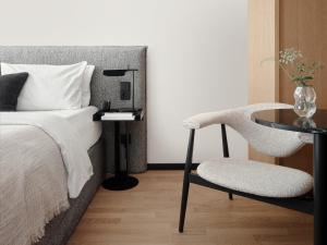 a bedroom with a bed and a table and a chair at Bob W Munich Old Town in Munich