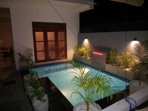 a swimming pool with plants in a house at night at Villa 58 Unawatuna in Unawatuna