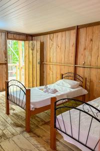 IrandubaにあるFlor da Mataの木製の壁の部屋にベッドが2つある