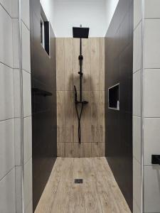 a walk in shower with a black and wooden wall at Lagon Bleu Complex 3 Villas 5min Walk to Beach - LBC in Flic-en-Flac