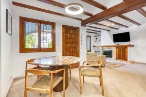 a dining room with a table and chairs and a tv at Casa Ortega in El Tosalet