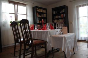 a dining room with a table with white tablecloths and chairs at "Campingplatz Altjessen 57" in Pirna