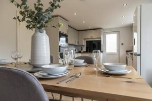 a dining room table with a vase on top of it at Letch Hill Drive in Bourton on the Water